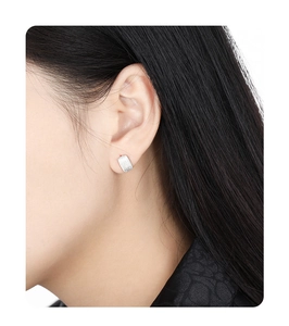 Close-up of minimalist rectangular brushed S925 sterling silver stud earring on model ear