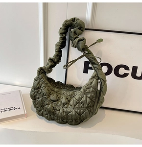 Detailed view of the dark green quilted dumpling bag with soft cloud-like pleats