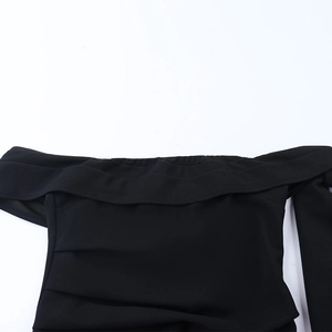 Vue macro détaillée du décolleté plissé à épaules dénudées sur cette robe noire moulante
