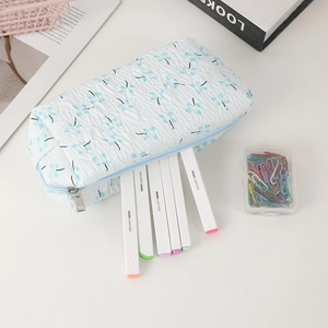 Detail of blue floral fabric pencil case with pleated texture and zipper closure