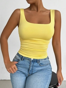 Close-up of bright yellow square neck knitted camisole top on model with denim