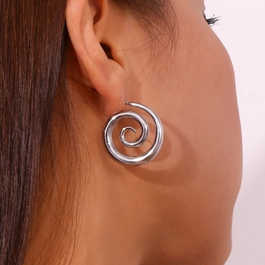Boucle d'oreille spirale argentée sur mannequin au design en métal minimaliste moderne