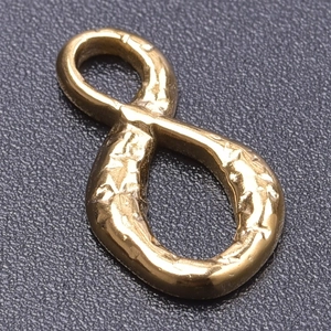Macro view of 18k gold plated infinity symbol pendant with irregular hammered texture