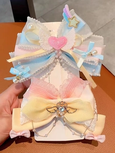 Detailed close-up of pink and blue lace bow hairclips with pearl tassels and heart charms