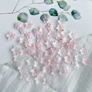 Detail of pink and white gradient resin cherry blossom beads with golden glitter center