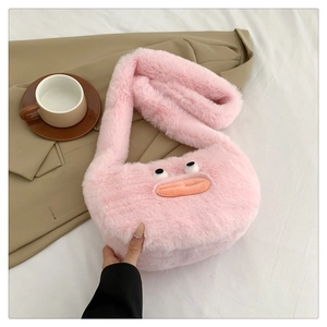 Pink plush crossbody bag with cartoon face shown on a neutral fabric background