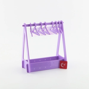 Detail view of purple acrylic earring rack with five matching hangers on a white base