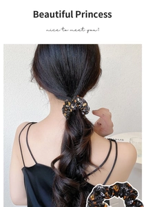 Close-up of Halloween satin scrunchie featuring festive pumpkin and ghost prints