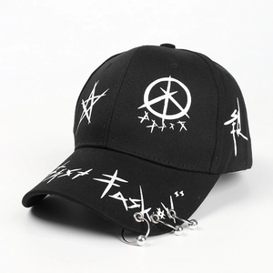 Detail of black punk baseball cap with silver metal rings and white graffiti prints
