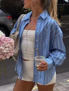 Detailed view of oversized blue striped shirt with front pocket and crisp cotton texture