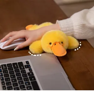 Macro detail of soft yellow plush duck wrist rest used for mouse support on office desk