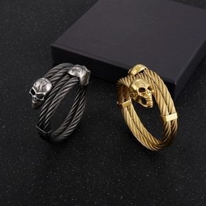 Detailed macro view of vintage skull cable wire bracelets in silver and gold finishes