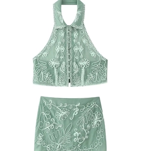 Mint green two-piece skirt set featuring floral embroidery and halter neck design