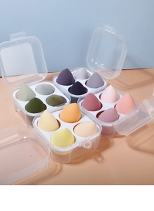 Detailed view of four multi-colored makeup sponge sets in transparent storage boxes