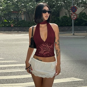 Detail of burgundy halter top with sheer lace patchwork and white lace mini skirt
