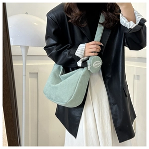 Détail du sac hobo en velours côtelé vert clair avec un petit porte-monnaie rond assorti