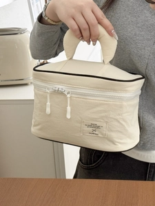 Minimalist beige nylon cosmetic bag with crescent handle and high-capacity storage