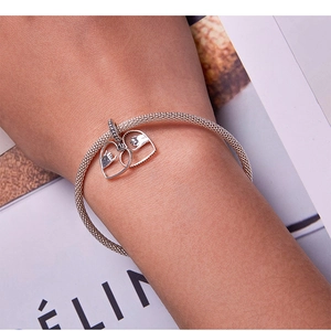 Close-up of interlocking double heart charms on a silver mesh chain bracelet