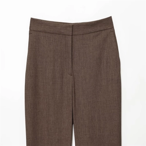 Détail de la ceinture du pantalon de costume marron foncé et texture du tissu premium