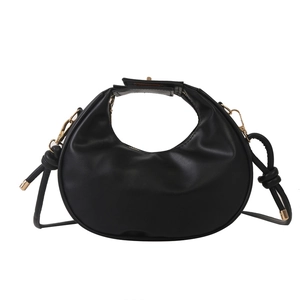 Minimalist black crescent handbag with gold hardware and knotted shoulder strap details