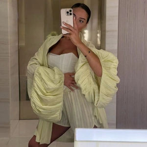 Détail de la texture plissée vert clair d'un ensemble décontracté cardigan et short