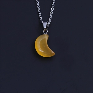 Detailed view of twist chain necklace with yellow crescent moon gemstone pendant