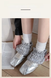 Detail of grey plaid lace leg warmers styled with silver metallic sneakers and white socks