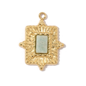 Detailed close-up of a vintage gold rectangular pendant with an emerald green stone inlay