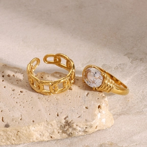 Elegant gold chain ring and oval rhinestone stainless steel ring on textured stone