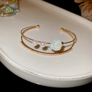 Détail d'un bracelet double couche plaqué or 18 carats avec fleur et zircons