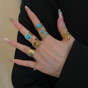 Detail of 18k gold plated stainless steel teardrop rings with turquoise and shell charms