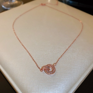 Macro detail of rose gold double interlocking rings necklace with zircon pavé setting