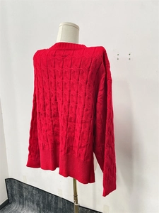 Detailed view of the red knit sweater showing cable knit texture and warm fabric
