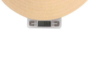 Detail showing kids embroidery sun hat weighing 55.3 grams on a digital scale