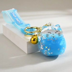 Cute lucky cat floating bottle keychain with blue liquid glitter and golden bell charm