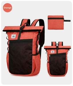 Detailed view of an orange waterproof folding backpack showing its compact folded state