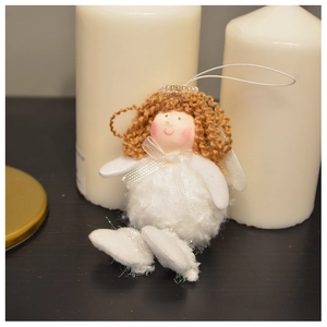 Detailed close-up of a plush angel Christmas ornament with white fur and knitting texture