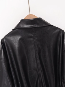 Detail view of the black faux leather flight jacket showing collar texture and stitching