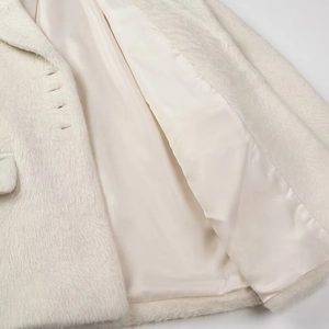 Detail of soft white plush wool coat showing luxurious long fur and smooth satin lining