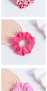 Detailed view of pink scrunchies with heart and floral patterns on elegant props