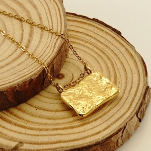 Hammered 18K gold plated stainless steel necklace with malachite stone on wooden base