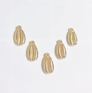 Macro view of five metallic gold shell pendants with top loops for DIY jewelry making