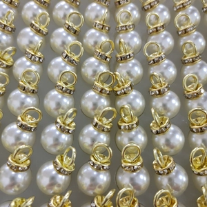 Elegant white ABS faux pearl pendants with gold rhinestone ring caps in a neat array