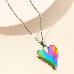 Detailed view of heart-shaped rainbow pendant with iridescent finish on a subtle gold chain