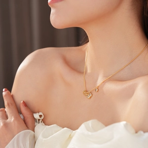 Primo piano di una delicata collana con ciondolo a fiore placcata oro 18k con zircone