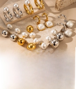 Collection détaillée de boucles d'oreilles en acier titane avec perles dorées et argent