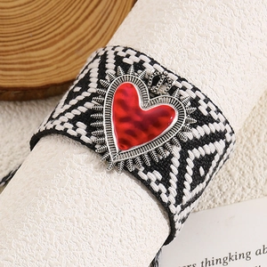 Close-up of black and white woven band with gothic red heart and silver crown pendant