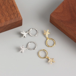Macro shot of silver and gold starfish hoop earrings with sparkling cubic zirconia pavé