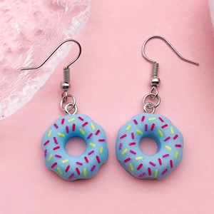 Blue resin donut earrings with colorful sprinkles and metal hooks on pink background