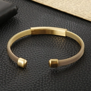Detailed macro view of the golden mesh weave texture and rectangle plate on the C-shaped cuff